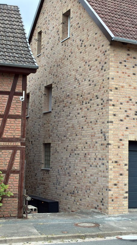 Zwei eng benachbarte Häuser, eines modern und das andere im Fachwerkstil.